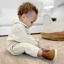 Load image into Gallery viewer, Baby sitting on the carpeted floor playing with cups wearing white corduroy jumpsuit and brown boots