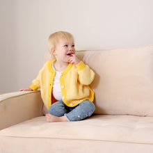 Load image into Gallery viewer, Toddler sitting on couch playing wearing yellow striped cotton cardigan over white shirt and blue denim jeans