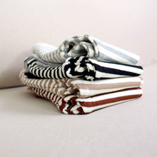 Load image into Gallery viewer, four pairs of folded striped cotton baby leggings stacked on top of each other. From top to bottom: light grey, black, tan and brown.