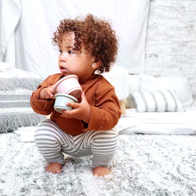 Load image into Gallery viewer, Baby squatting wearing a brown mock-neck long sleeved turtleneck with scalloped hems and light grey and white striped cotton baby leggings with a light grey ribbed cuff at the bottom.