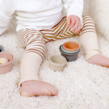 Load image into Gallery viewer, baby sitting wearing a white long sleeve and tan and white striped cotton baby leggings with tan cuff at bottom.
