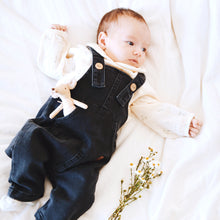 Load image into Gallery viewer, baby laying wearing blue denim overalls