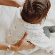 Load image into Gallery viewer, baby sitting wearing white baby tunic with navy blue polka dots and peter pan collar