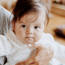 Load image into Gallery viewer, baby from waist up wearing peter pan color white shirt with navy blue polka dots