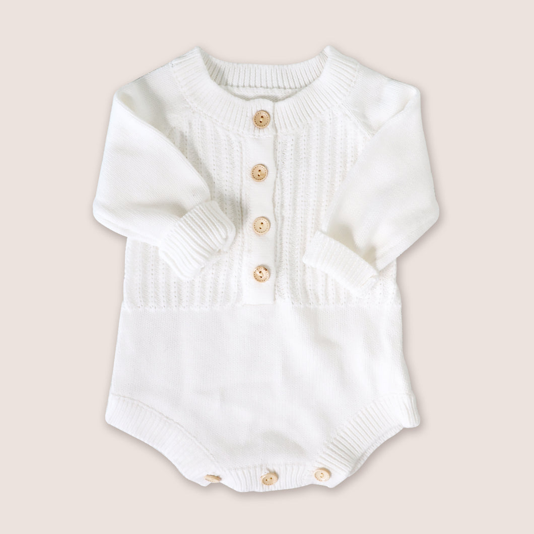 Baby white long sleeved knit romper with four buttons in the center and three buttons at crotch opening 