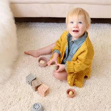 Load image into Gallery viewer, Baby sitting playing wearing denim cotton romper with yellow knit pom pom cardigan
