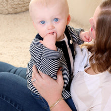 Load image into Gallery viewer, Baby sitting on moms lap with fingers in mouth wearing white shirt and navy striped cotton cardigan
