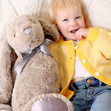 Load image into Gallery viewer, Toddler sitting next to stuffed bunny wearing yellow striped cotton cardigan over a white shirt and blue denim jeans
