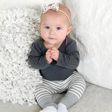 Load image into Gallery viewer, A baby sitting wearing a long sleeved dark grey shirt tucked into light grey and white striped cotton baby leggings with light grey ribbed cuff at bottom. 
