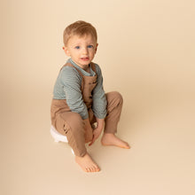 Load image into Gallery viewer, Baby sitting wearing brown cotton jumpsuit and green striped long sleeved henley shirt
