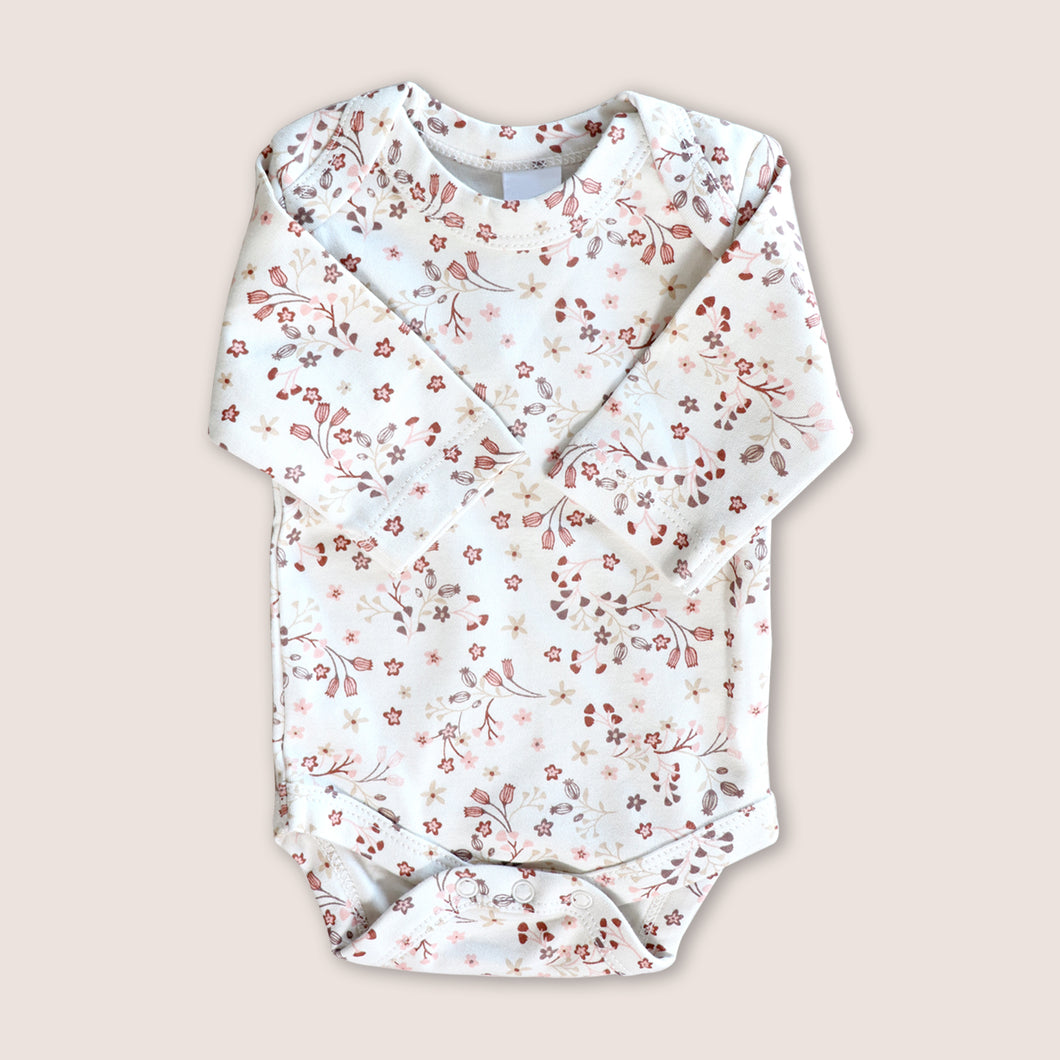 white baby onesie with pink floral design