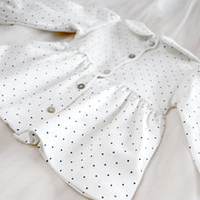 Load image into Gallery viewer, back of white baby tunic with navy blue polka dots and peter pan collar featuring mother of pearl buttons
