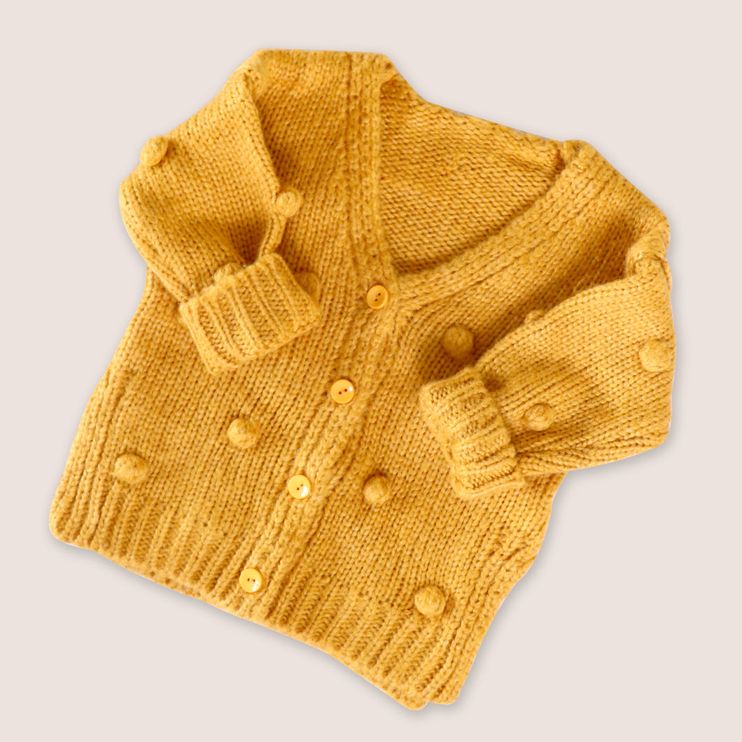 Baby yellow knit pom pom cardigan with four center buttons