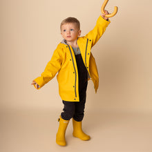Load image into Gallery viewer, toddler standing wearing yellow rain jacket, dark denim overalls and yellow rainboots
