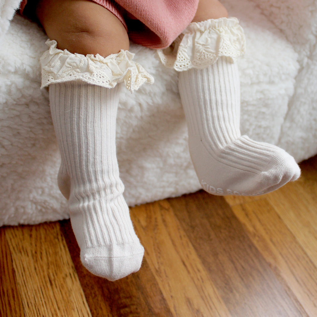 baby's legs wearing cream ruffle socks