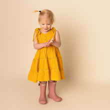Load image into Gallery viewer, toddler standing with hands together wearing yellow gold gingham strapless tiered dress and pink rainboots
