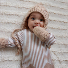 Load image into Gallery viewer, baby laying on cream blanket wearing latte colored knit bonnet and latte colored baby mittens and a vertical white and tan striped onesie
